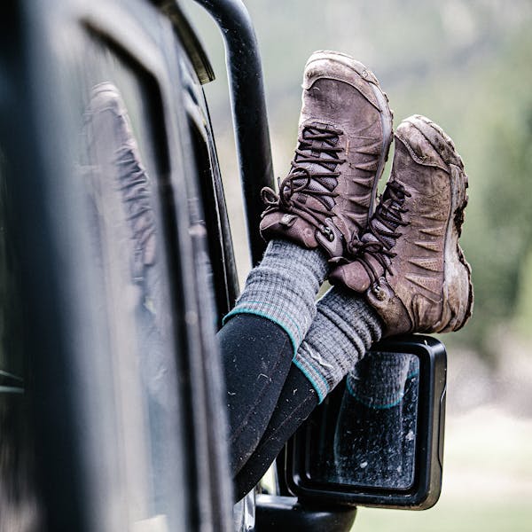 A person wearing the women's Oboz Sypes relaxing their legs out of a jeep door while on a mountain expedition.