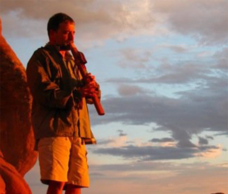 Peter Carioscia playing music on top of an mountain