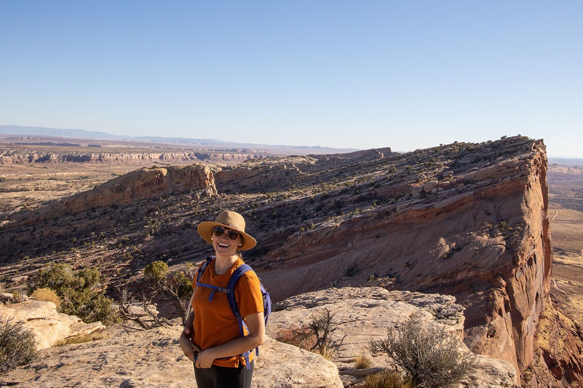 Happy woman hiking in Utah Bear Ears on a sunny day.