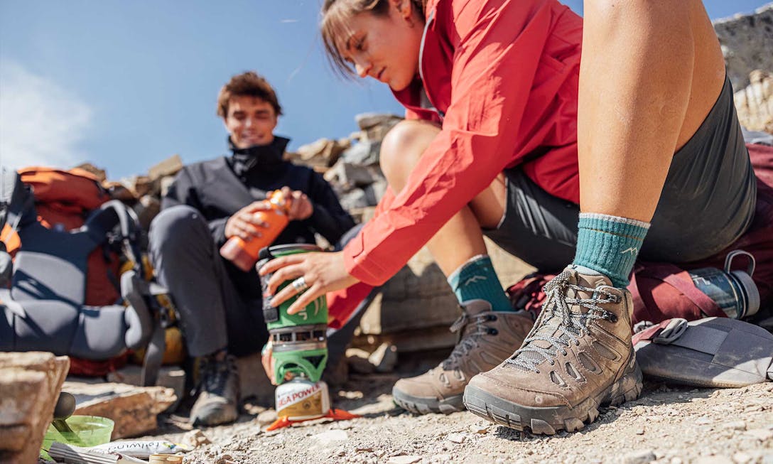 Backpackers wearing Oboz Sawtooth X hiking boots while preparing food in the backcountry
