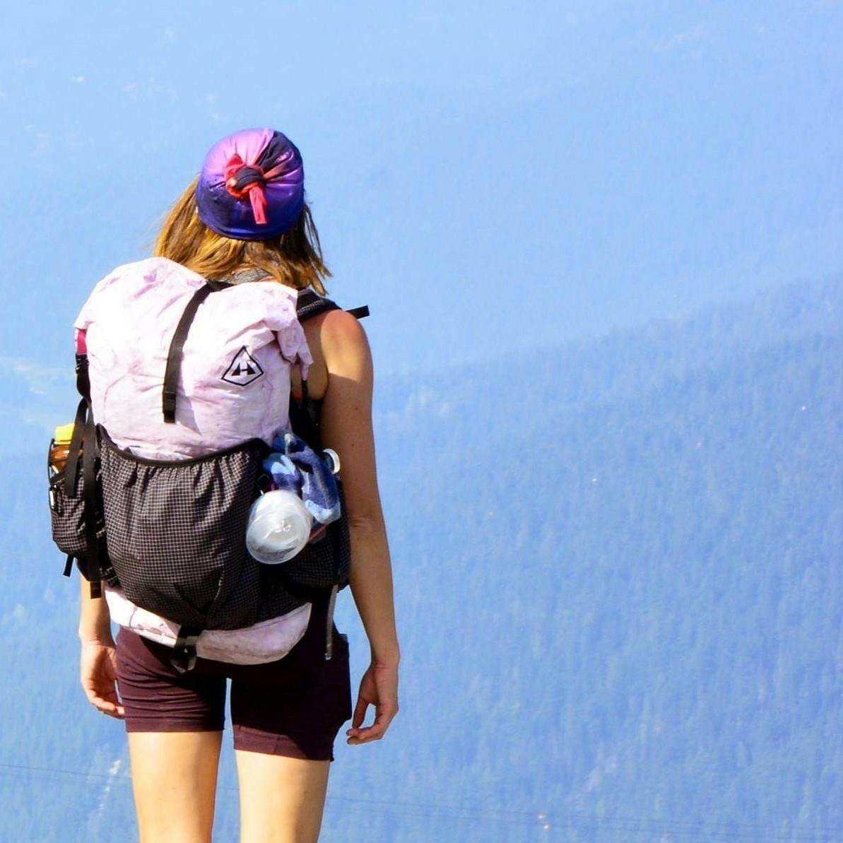 Woman looking at the incredible view of the valley below from peak.