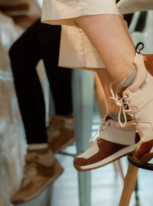 Two women sitting on barstools in Oboz boots