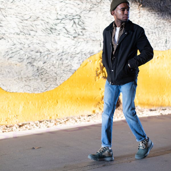 Man walking in front of a graffiti wall wearing Oboz Burke Chukka casual shoes.