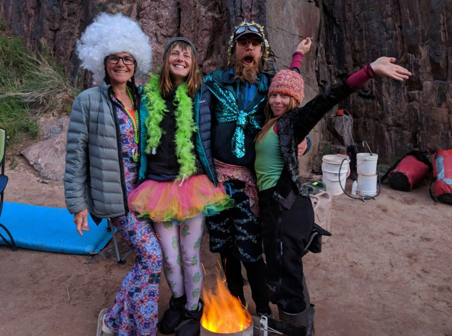 Group of hikers wearing funky costumes celebrating near a fire pit