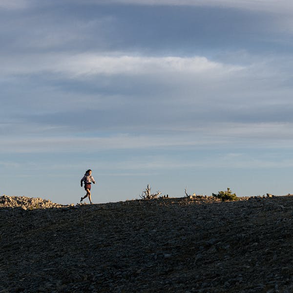 Woman running on ridgeline in Oboz hiking boots.