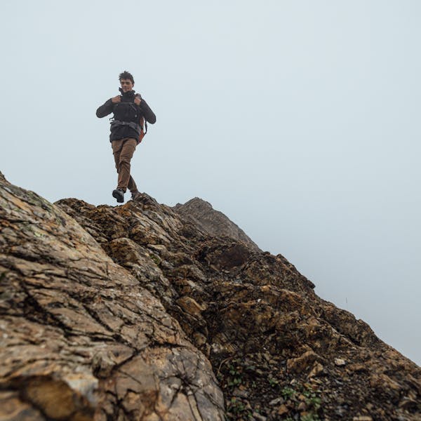 Hiker trekking up a rocky slope in the Sawtooth X hiking boot. 