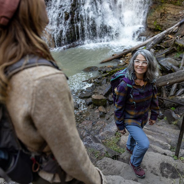 Two women enjoying a beautiful view the Ousel waterfalls near Big Sky in the Ousel hiking boot.