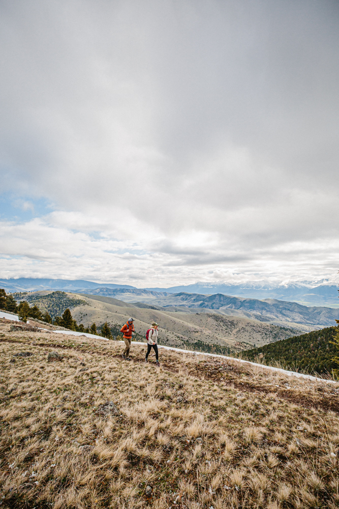 Two hikers on a trail wearing Oboz Hiking shoes with mountain ranges in the background