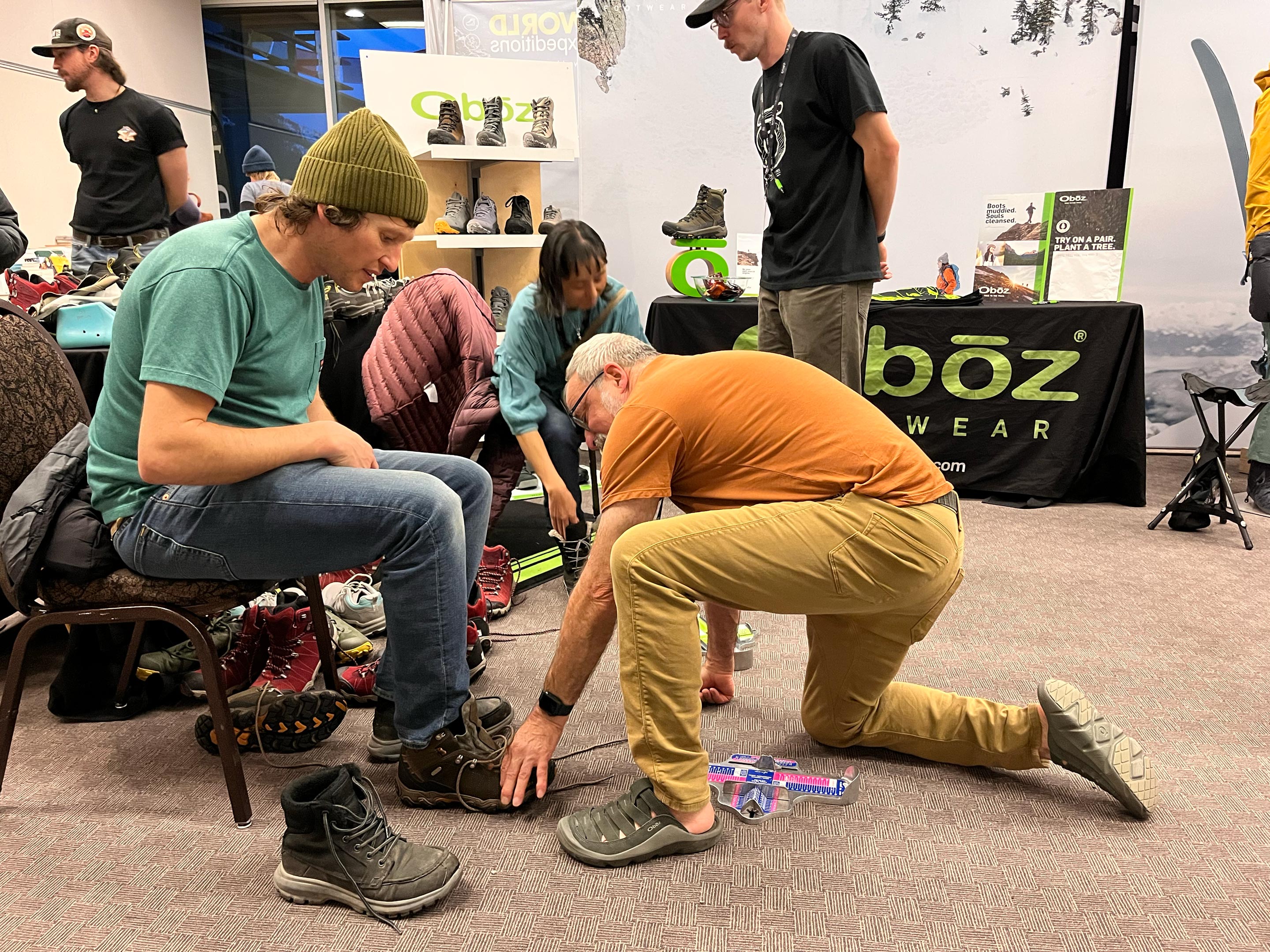 Oboz employees fitting customers for hiking boots.