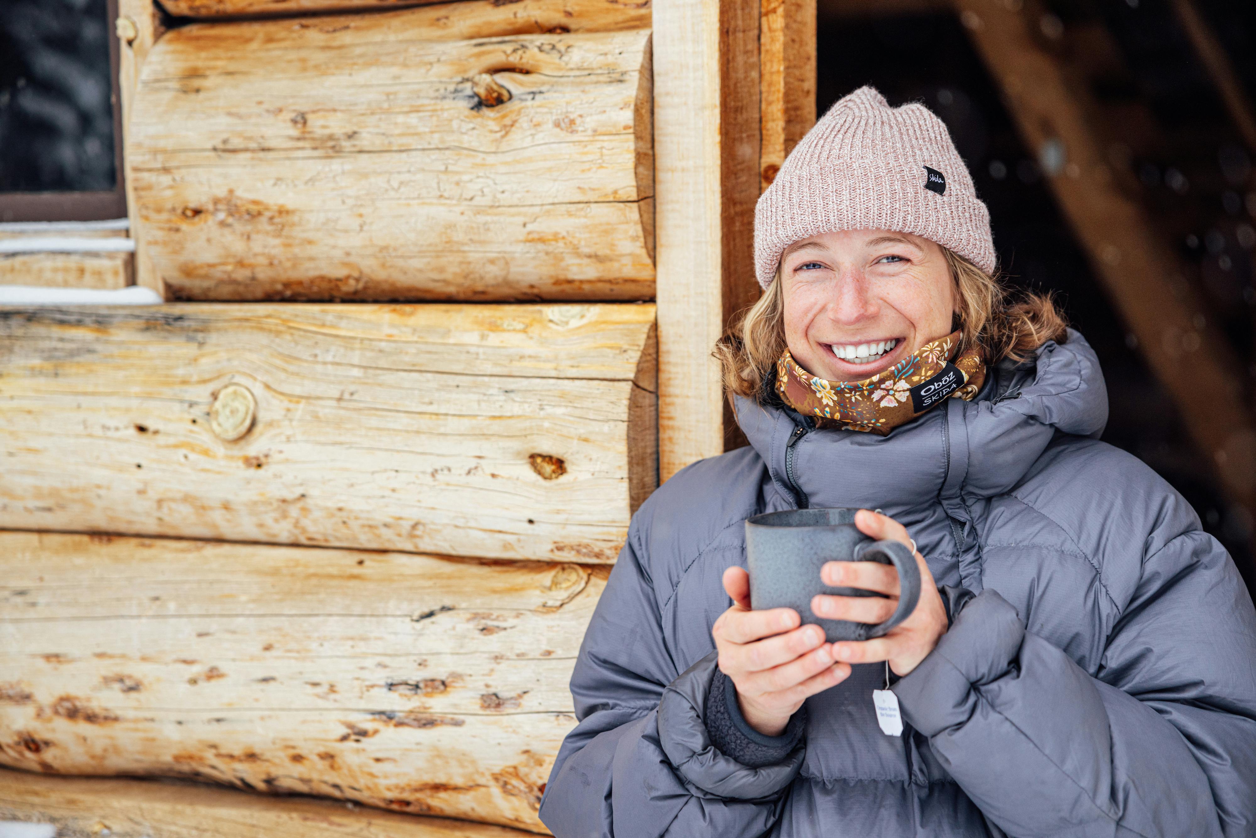Corinne Prevot, founder of Skida enjoying a tea at a cabin in Cooke City.