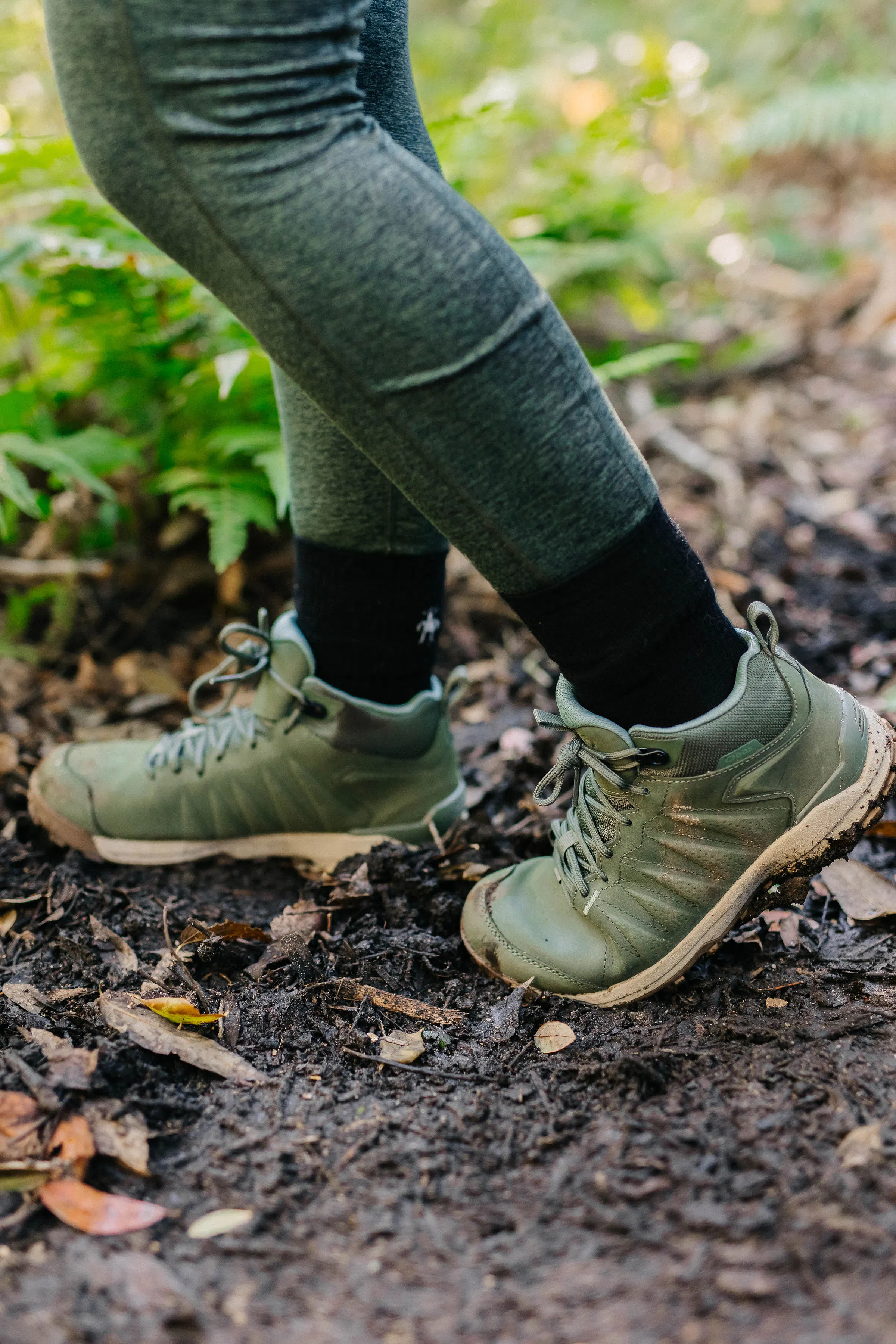 Hiker on a muddy trail wearing the Oboz Sypes Mid Leather B Dry Hiking boots