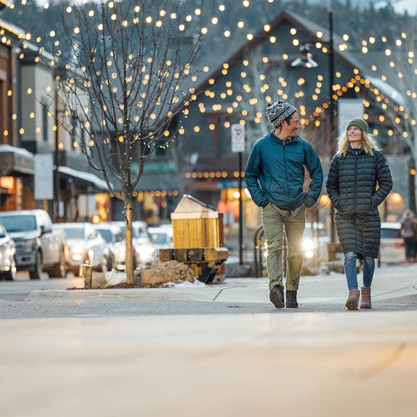 Two people in Oboz casual shoes walking down the street in Big Sky, Montana.
