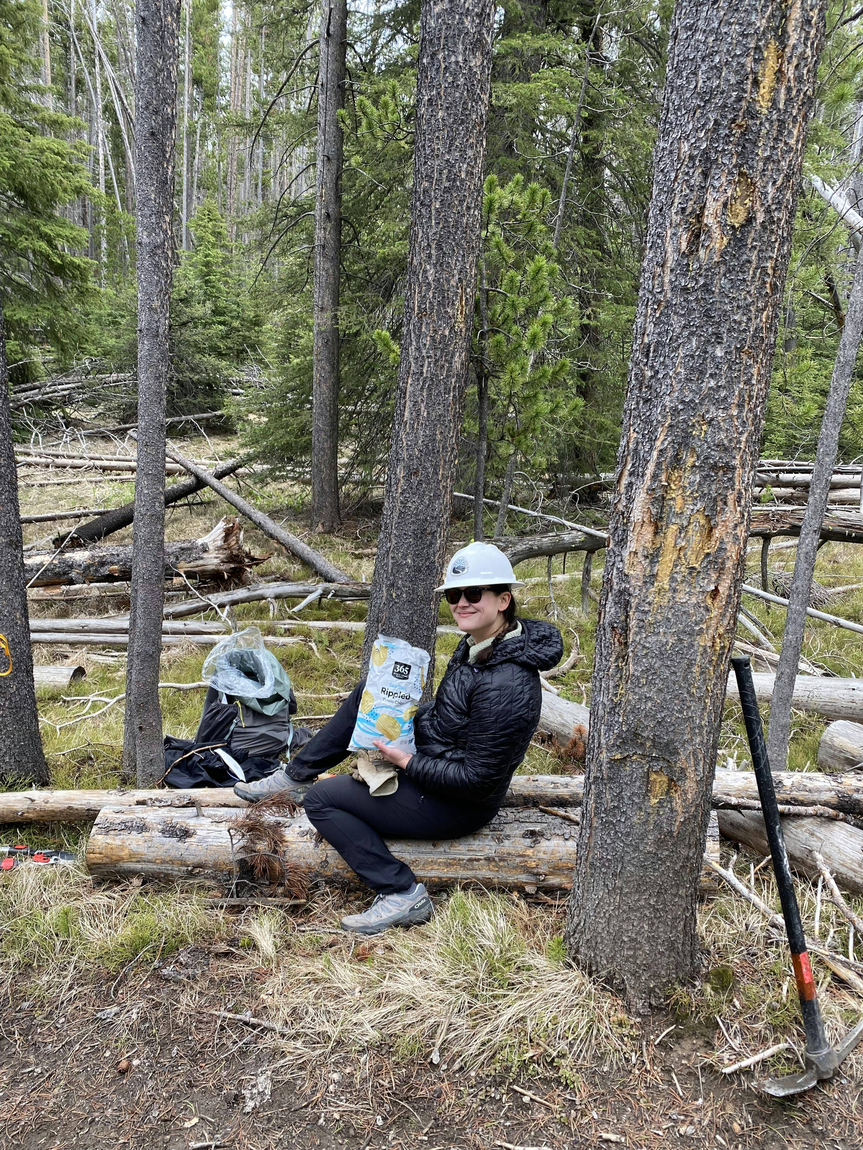 Woman taking a snack break from trail maintenance in Oboz Sawtooth X Low hiking shoes.