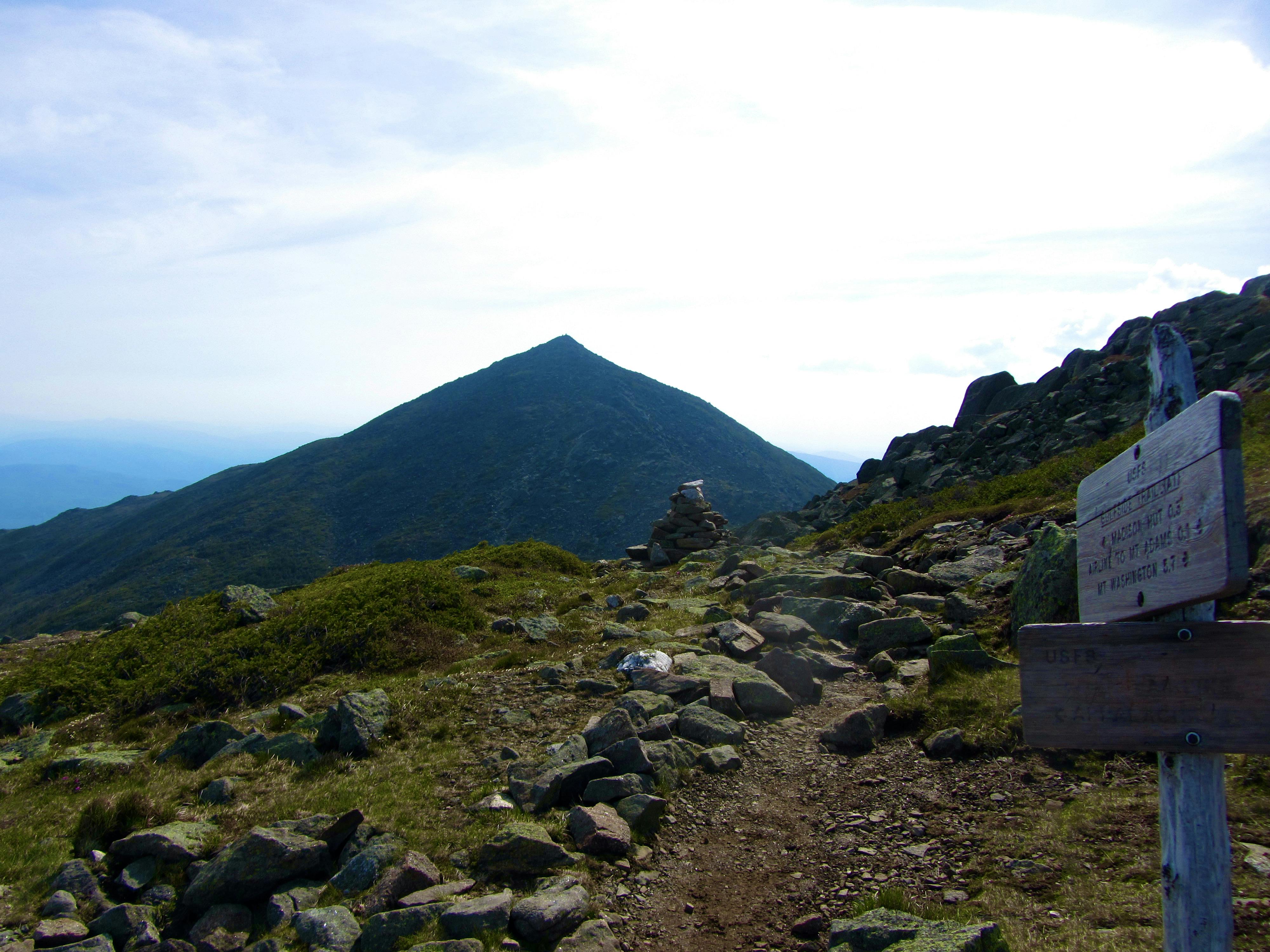 Trail sign with a mountain in the background