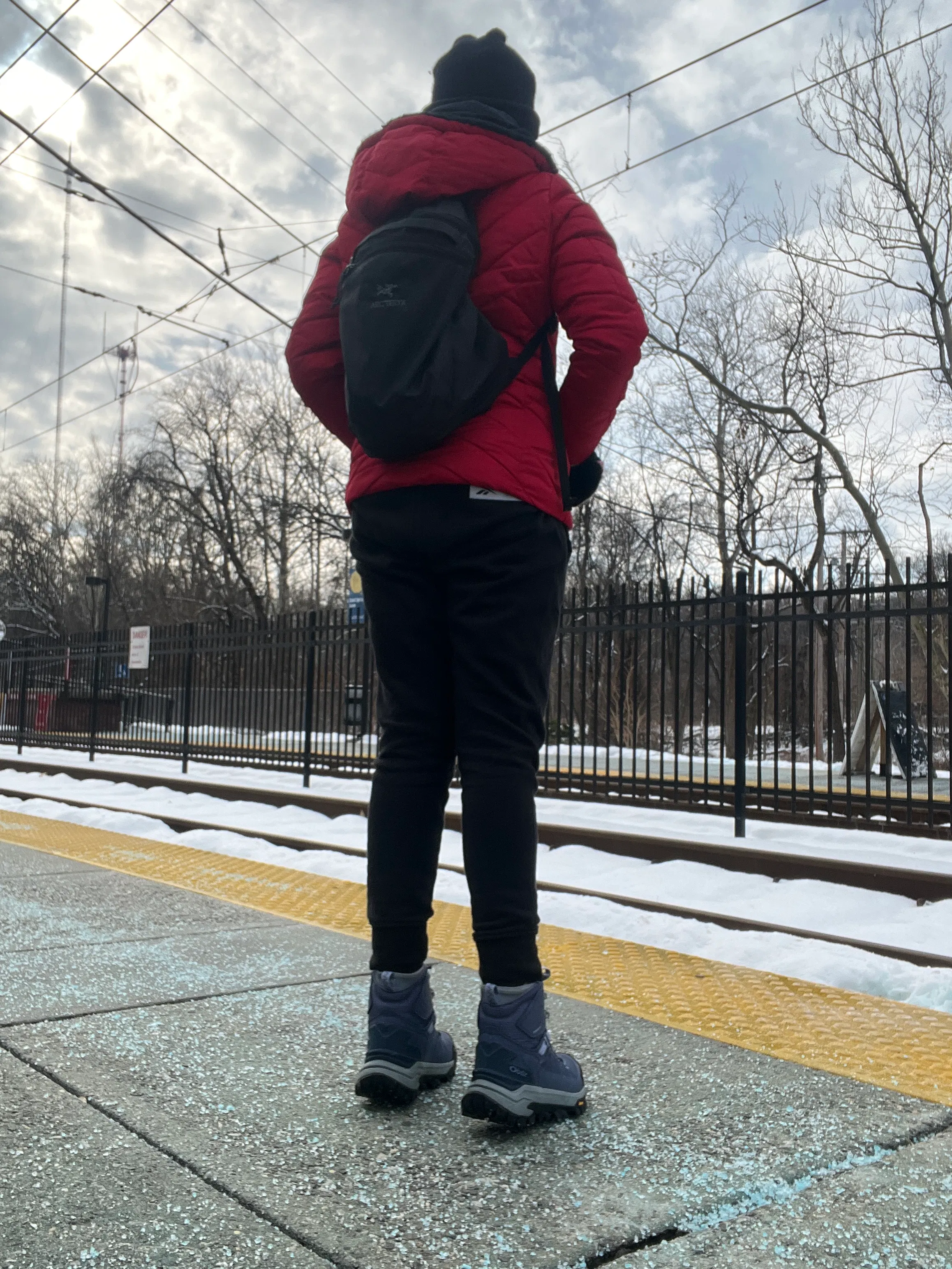 A hiker waits for the light rail in their Oboz Bangtail hiking shoe