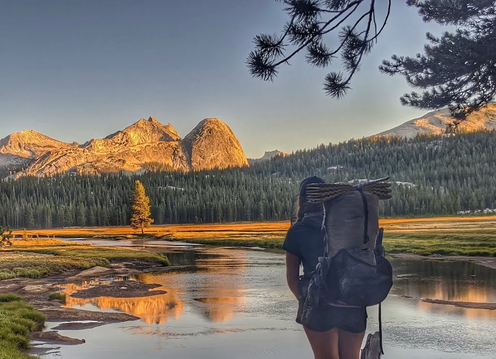 A hiker takes in a beautiful view during a thru-hike on the PCT