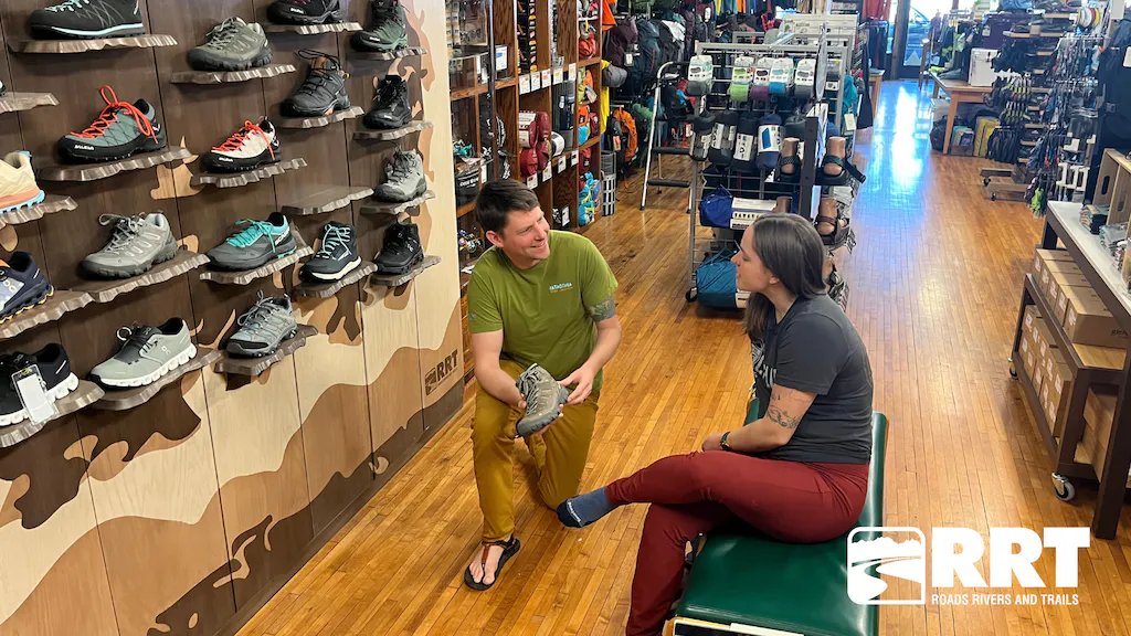 An employee at RRT helping a customer be fit for an Oboz hiking shoe