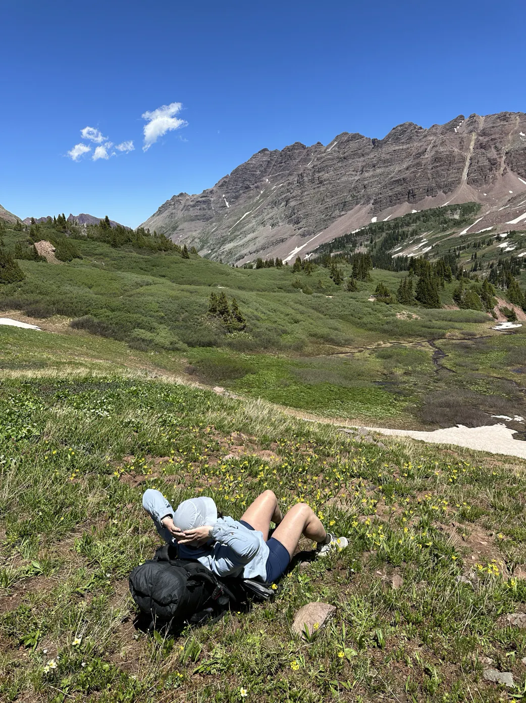 Kylie relaxing in a mountain meadow after a long day on the trail.