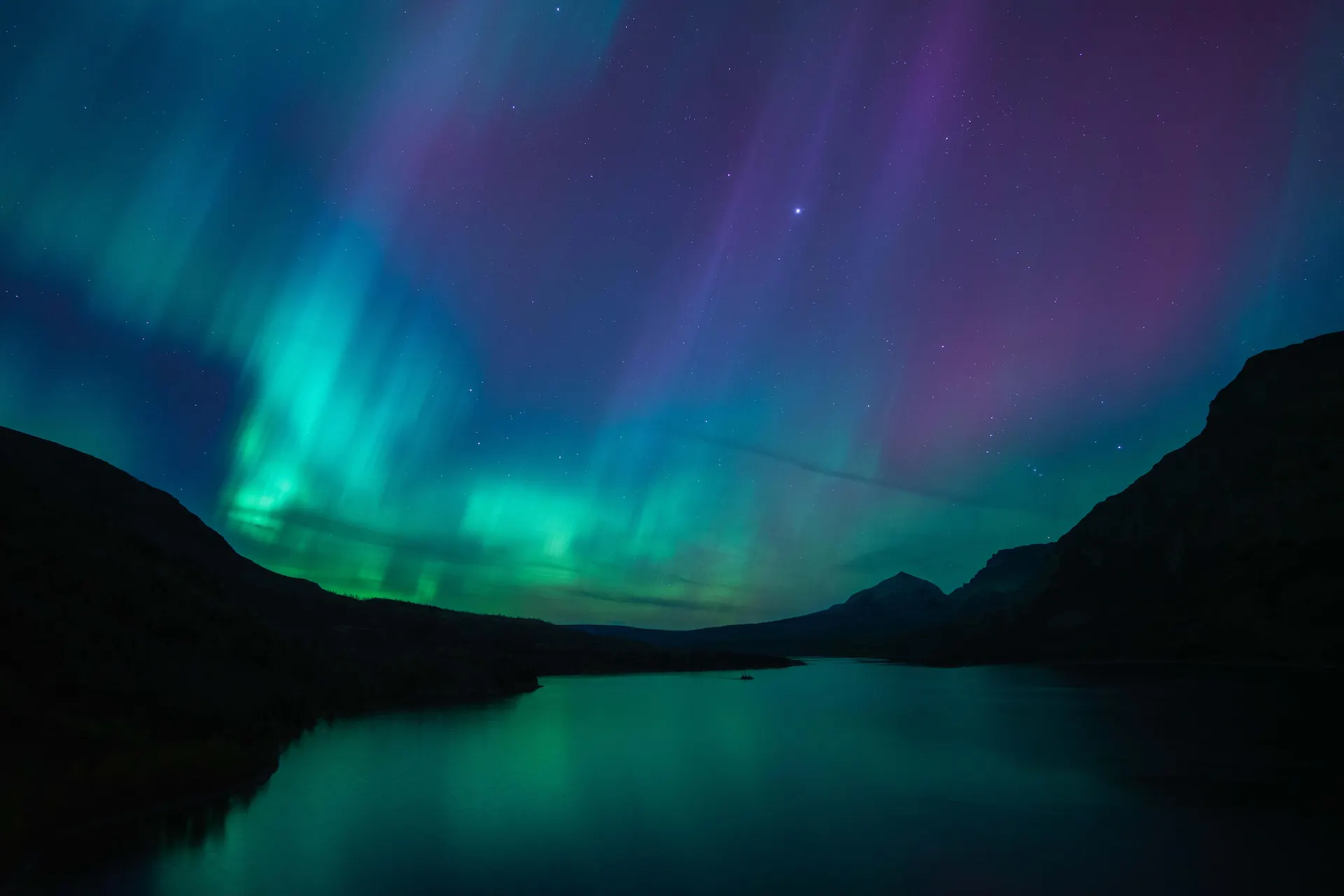 The northern lights above a lake in Glacier, MT