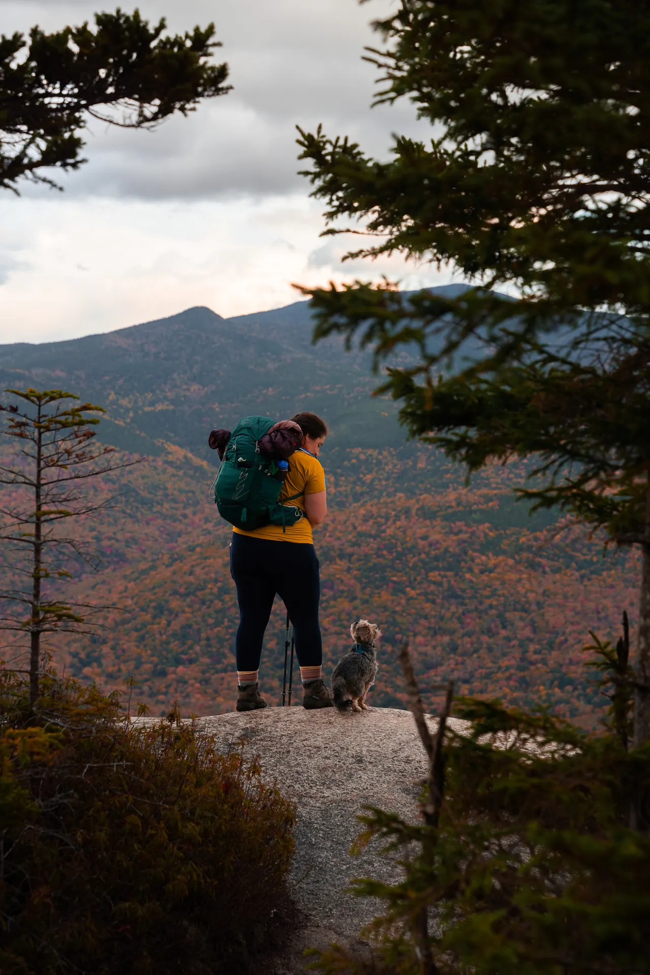 A hiker in Oboz Footwear stands at the summit of a peak in the Adirondack mountains.