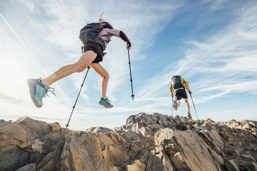 Two hikers fast packing on rocky terrain in Oboz Katabatic low height shoes.