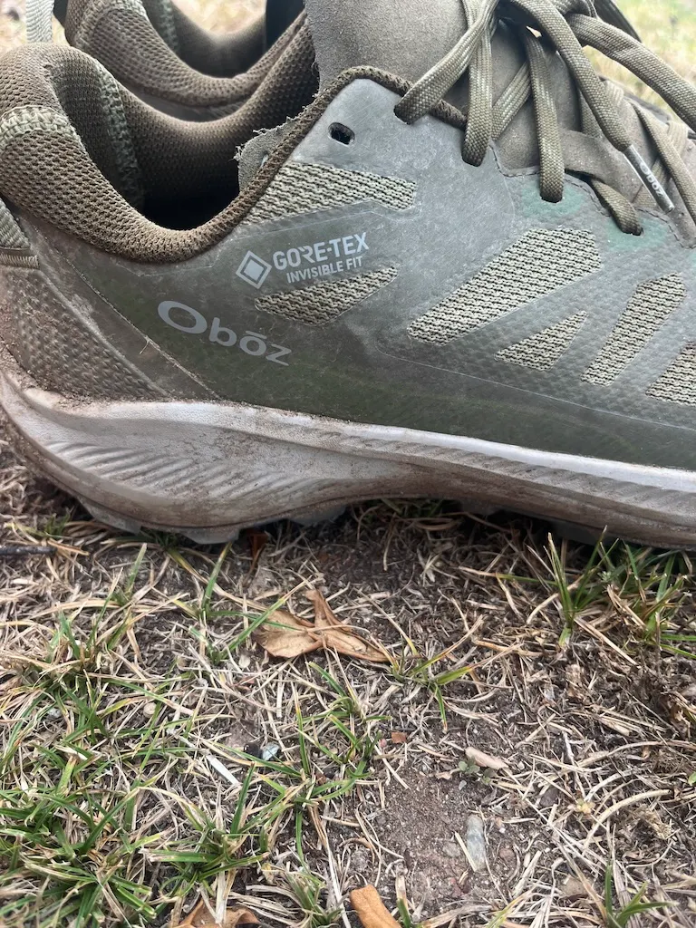A pair of green Oboz hiking shoes in the grass.