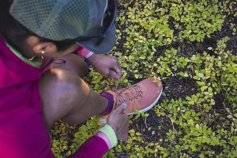 A hiker laces up their Oboz hiking shoe