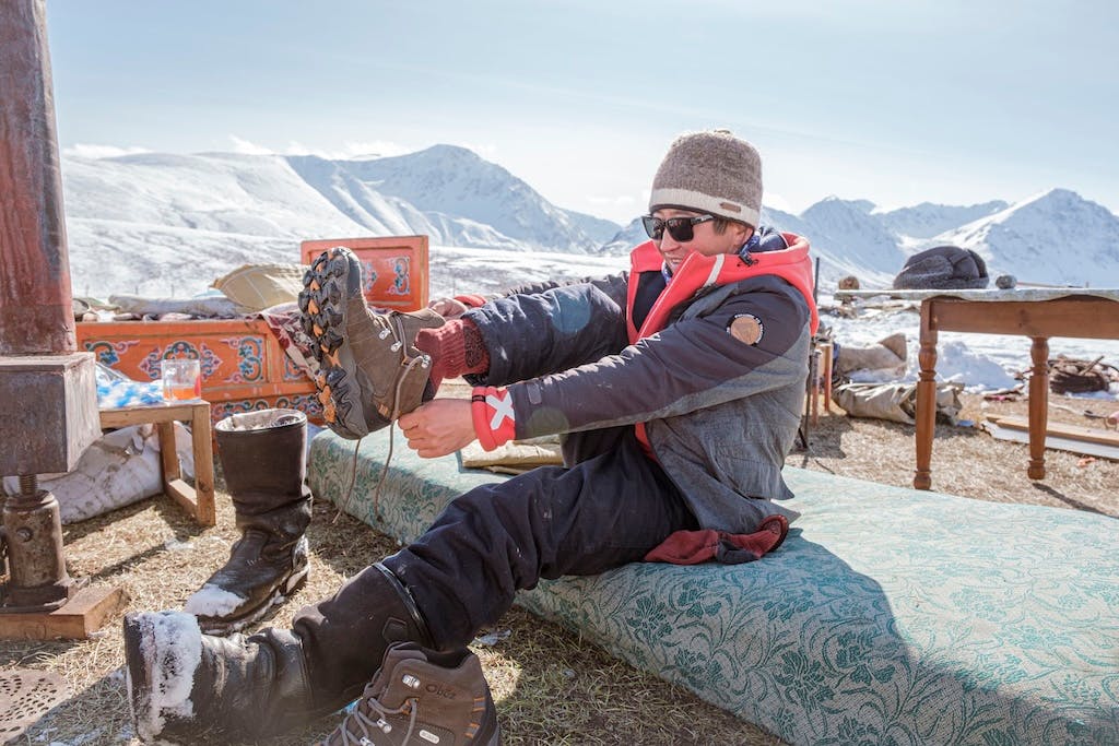 A hiker pulls on their Oboz Bridger hiking shoe