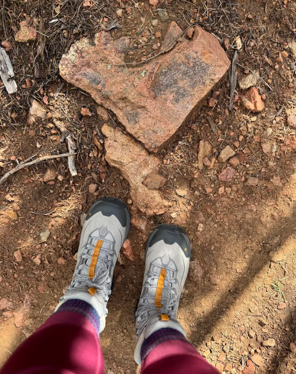 A pair of Oboz hiking shoes on rocky terrain on a backpacking trip