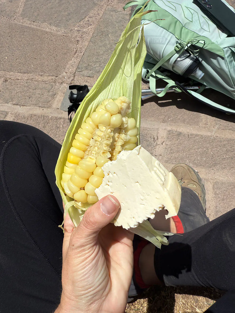 A hiker holds a corn snack during a hiking trip.