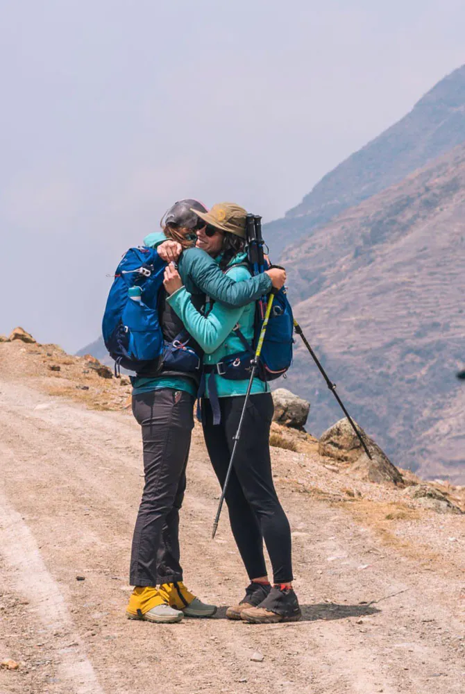 Two hikers in Oboz footwear embrace after hiking to Machu Picchu