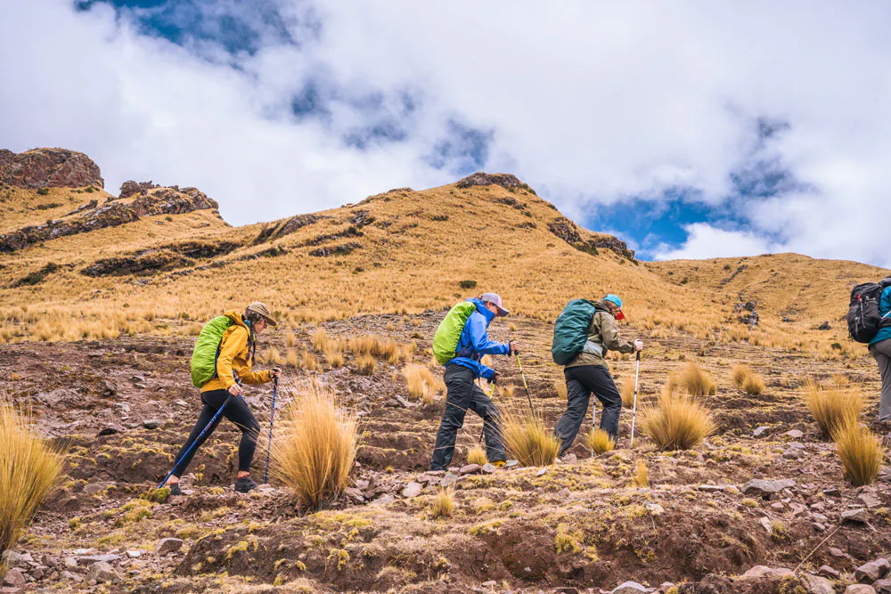 Hikers in Oboz footwear summit a long trail in Peru.