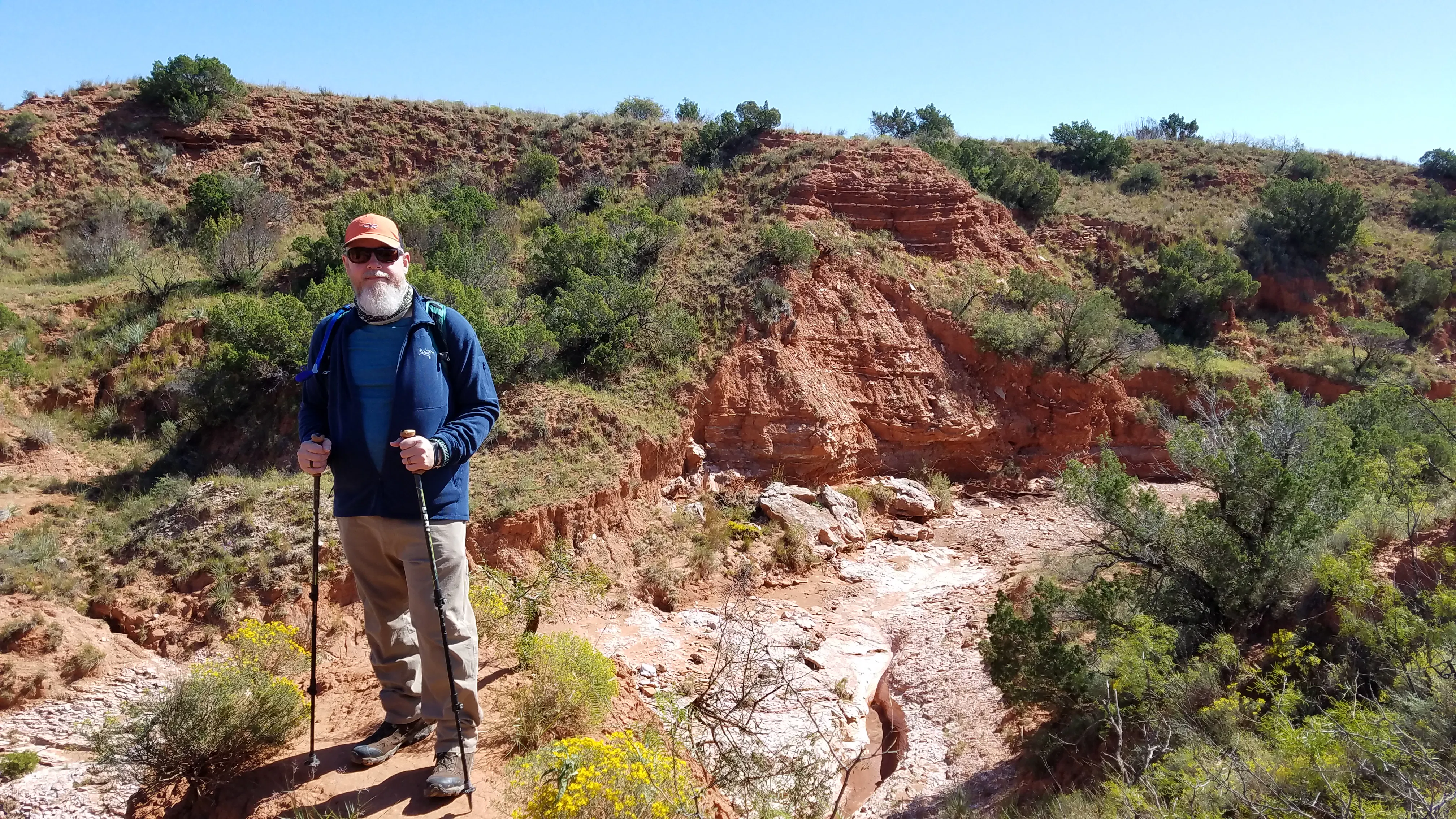 A hiker in southwest terrain with treking poles in Oboz