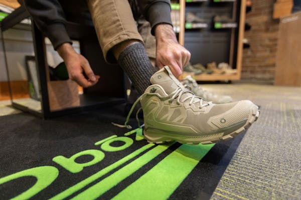 A person tries on an Oboz Katabatic hiking shoe at a dealer. 