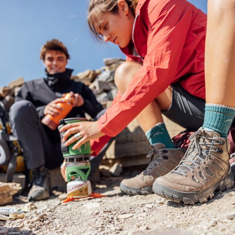 Two hikers at camp boiling water in Oboz Sawtooth hiking boots. 
