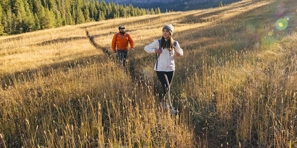 Hikers wearing Oboz boots in a mountain meadow.