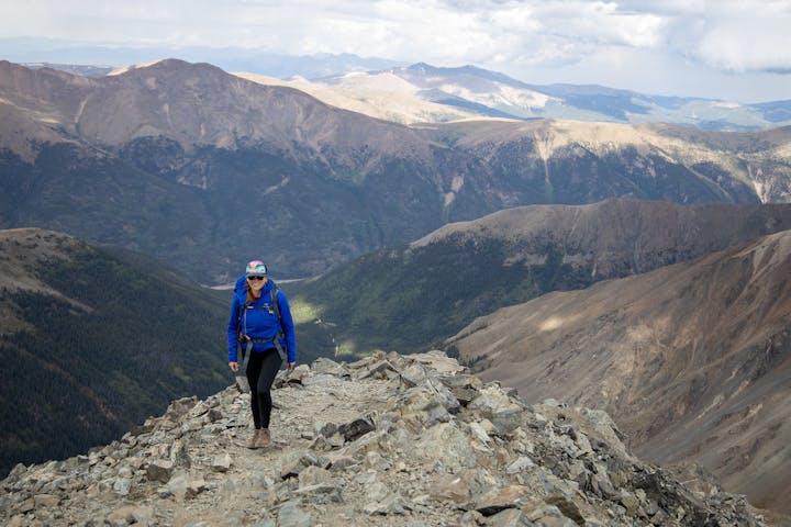 Hiker posing in Oboz hiking boots in front of beautiful mountain ranges