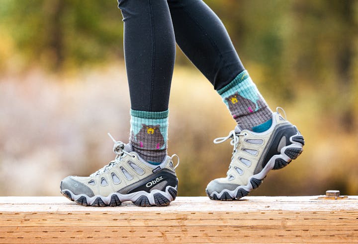 Person walking on a bridge in the Oboz Sawtooth II Low hiking boot.