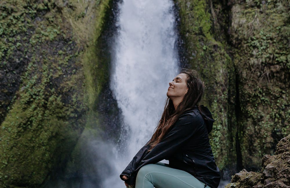 Lindsay Kagalis smiling in front a waterfall in the Women's Bozeman Mid shoes