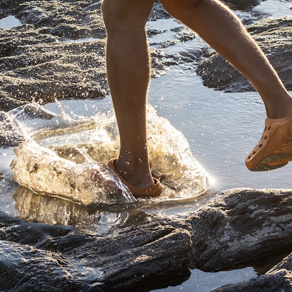 Person splashing in tide pools wearing the Oboz Whakata Coast sandal.