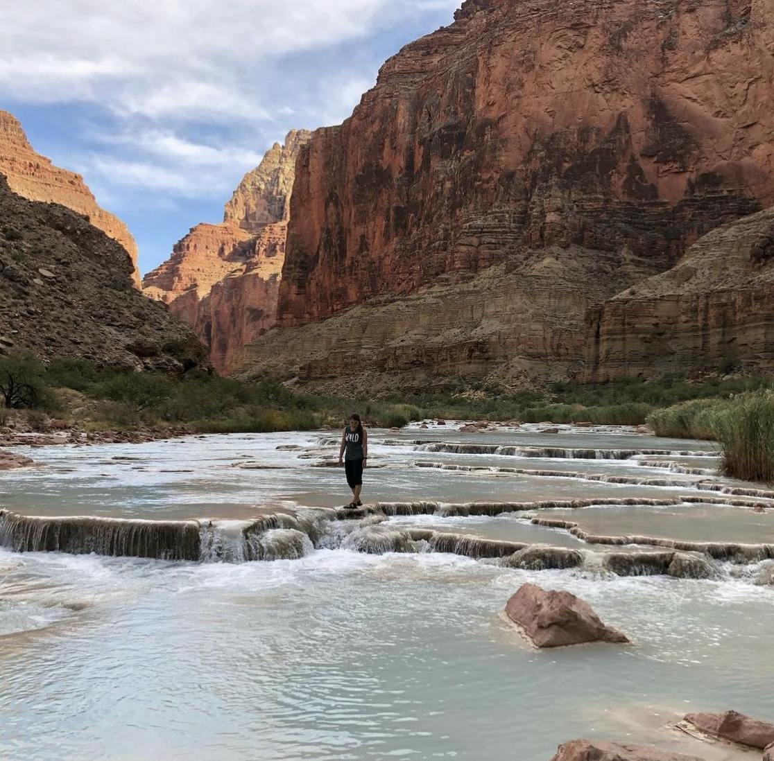 Hiker walking around in the water at Havasu Falls