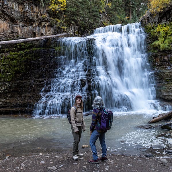 Two women at a waterfall in the Ousel hiking boot.