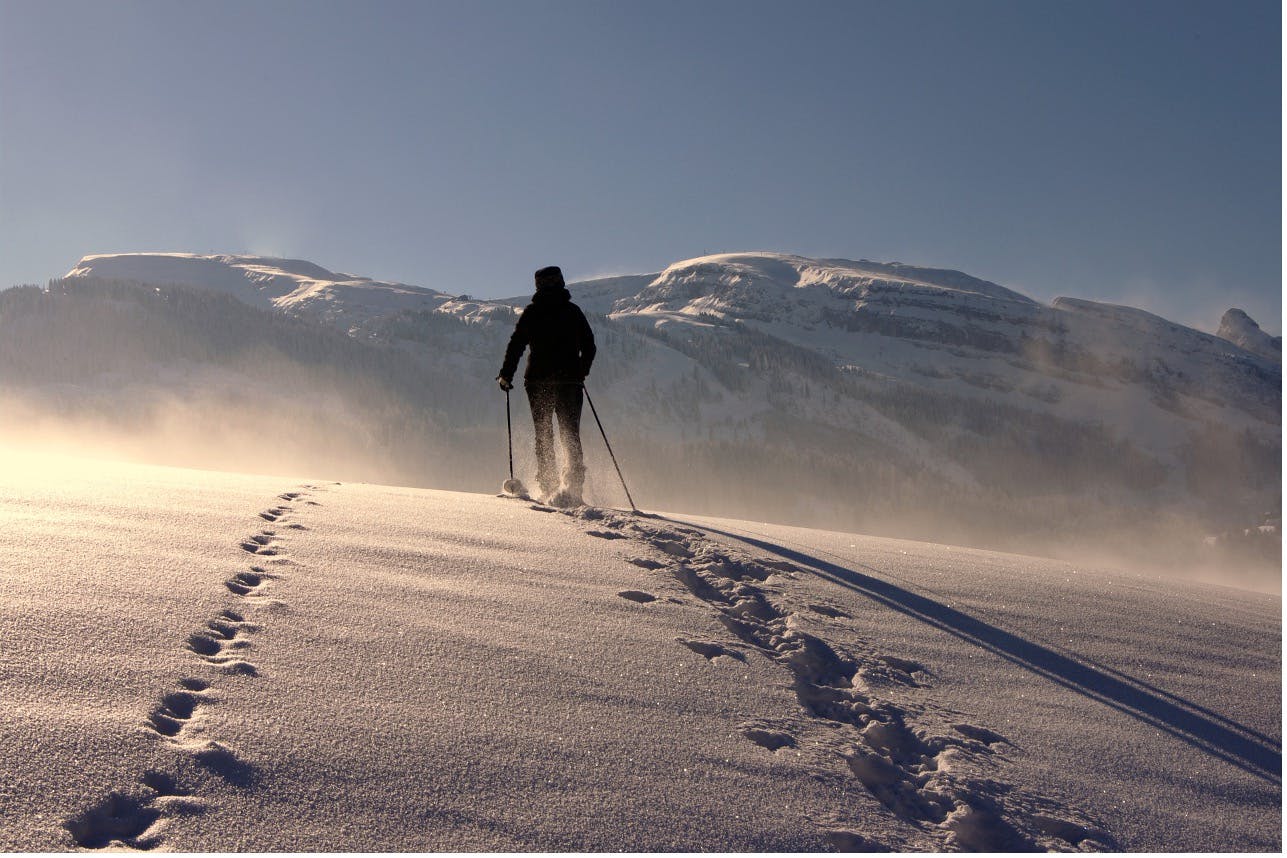 Skier in the backcountry ascending a snowy mountain with a touring set up.