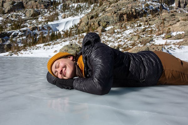 Kylie Yang lays on a frozen lake during winter hike. 