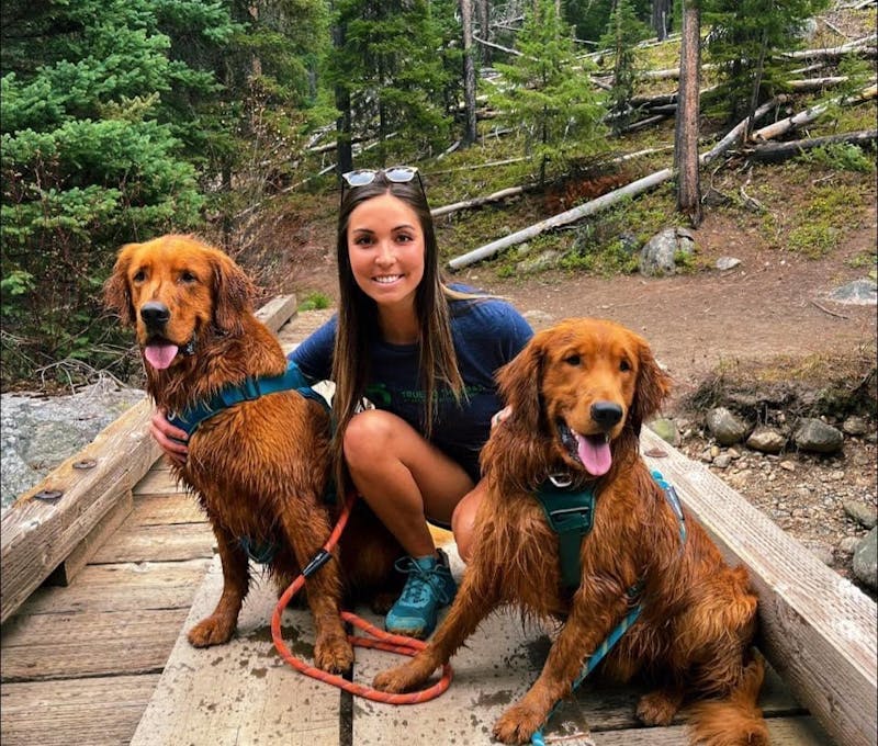Taylor Nishimoto hiking with her two dogs Moose and Otter.