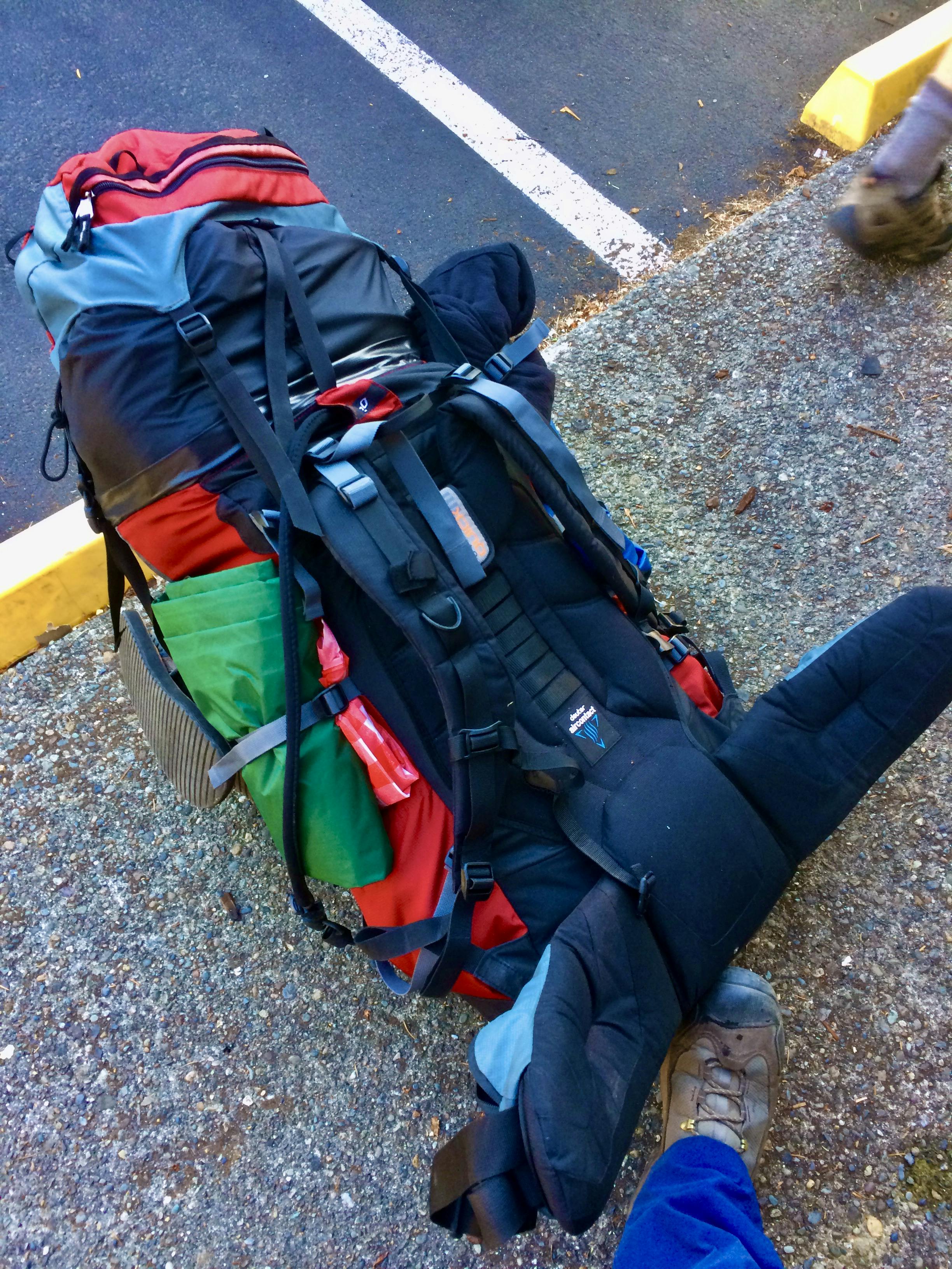 Loaded backpacking backpack on the ground.