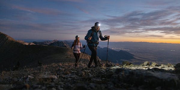 Hikers climbing high alpine terrain during sunset while wearing Oboz Katabatic hiking shoes