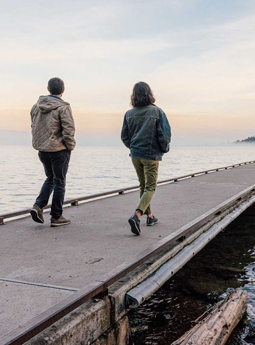 Two people stroll down a pier in Oboz town styles