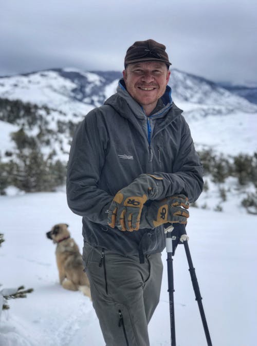 Dan Stahler smiling in a snow covered Yellowstone National Park.