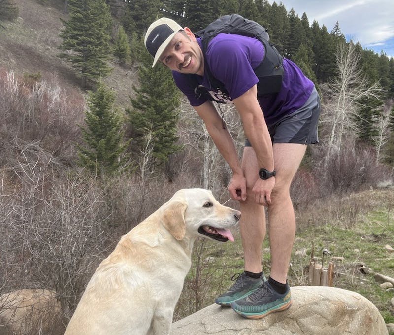 Oboz employee hiking with his happy dog.